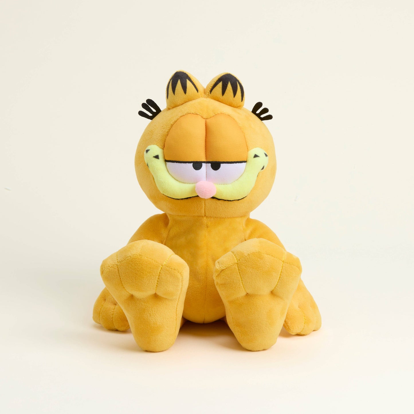 Plush toy of a cartoon cat character Garfield on a beige background