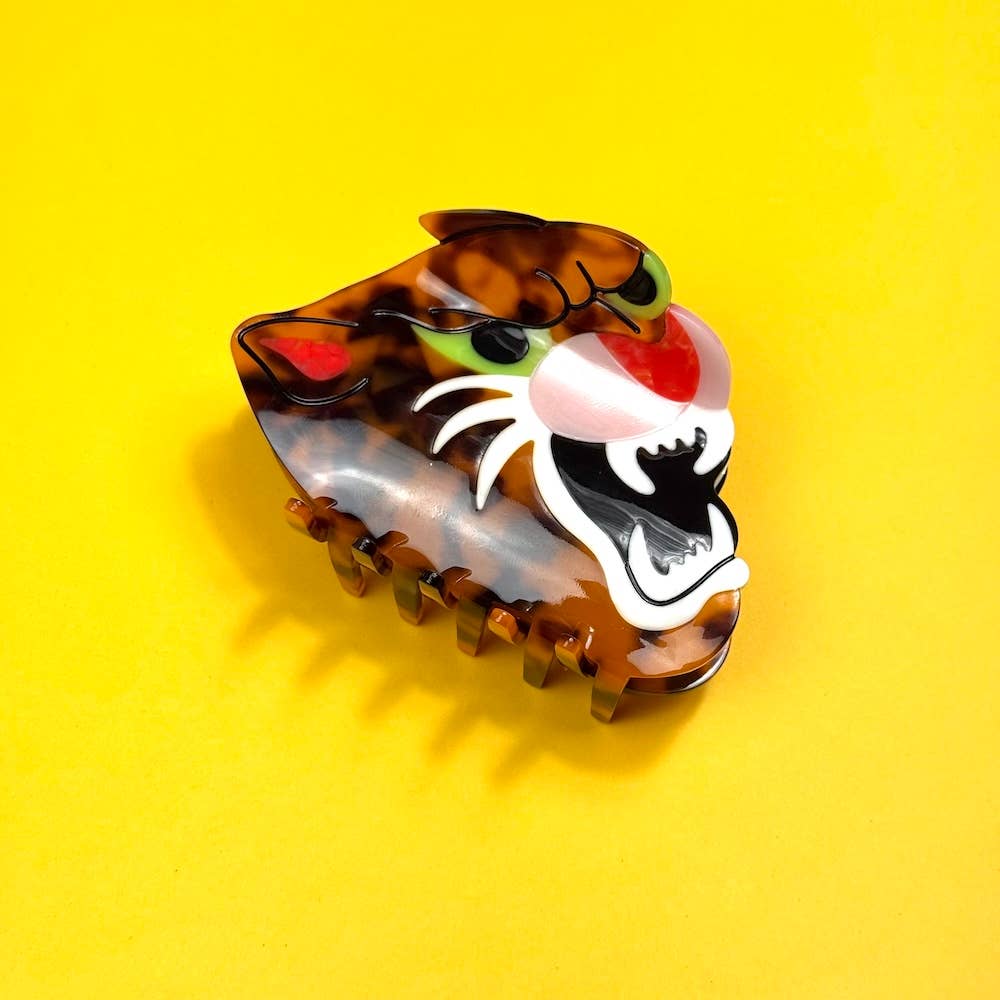 Tortoiseshell-patterned hair clip with a tiger design on a yellow background