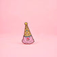 Pink clown figurine with a yellow party hat on a pink background
