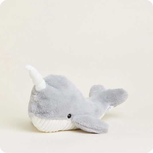 Plush toy narwhal on a light beige background