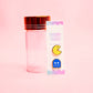 pac man and ghost earrings with glass bottle on a pink background
