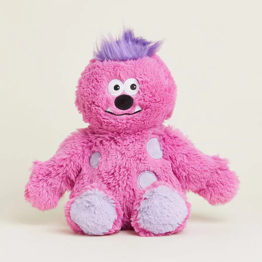 Pink plush toy with purple hair on a light beige background